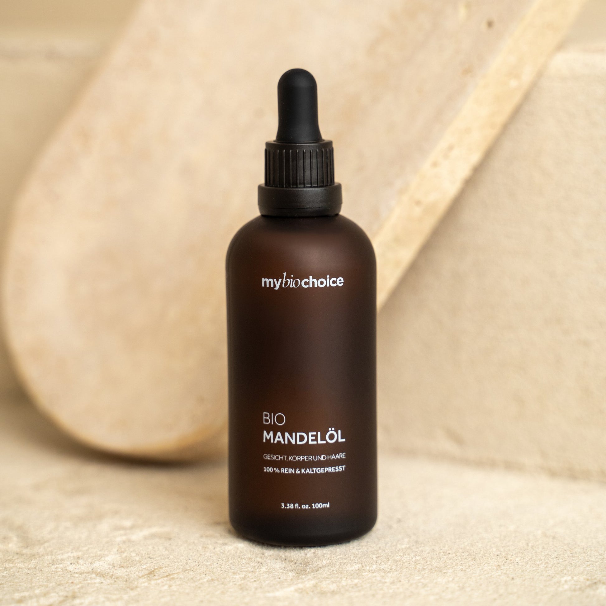 mybiochoice Bio Mandelöl-Flasche auf hellem Steinuntergrund, für eine minimalistische Ästhetik.