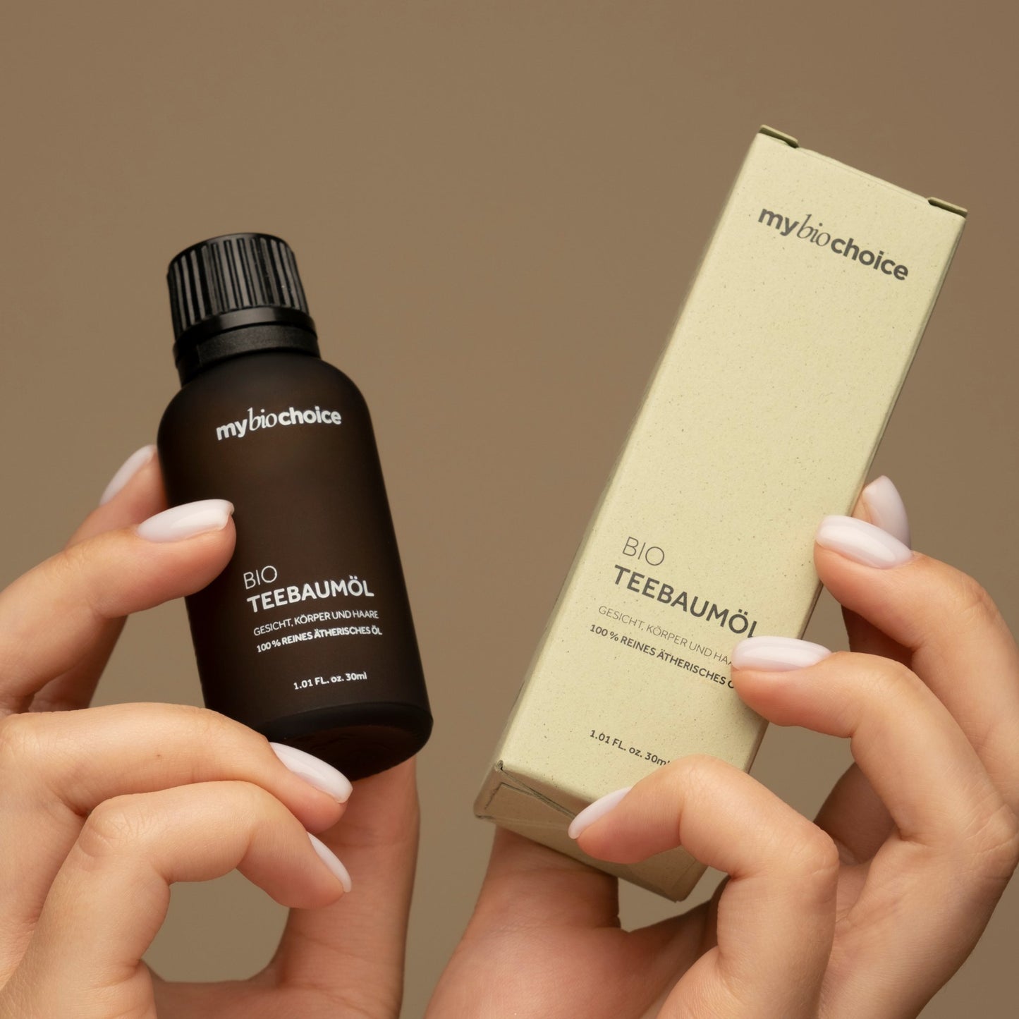 Nahaufnahme einer Person, die eine Flasche "mybiochoice" Bio Teebaumöl an ihre Schulter hält und das Produkt hervorhebt.